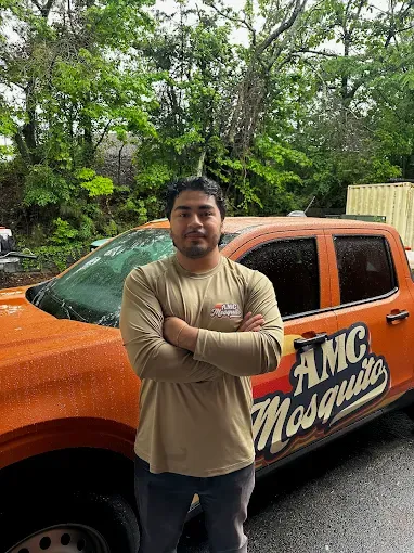 An AMC Mosquito team member beside a branded service truck.